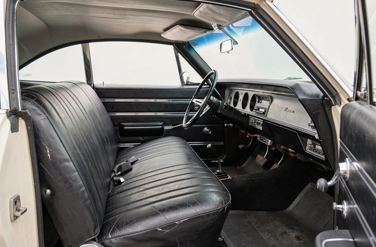 Intérieur authentique d'une Chevrolet Impala 1967 4 portes avec banquette vinyle noire, tableau de bord d'origine et volant chrome